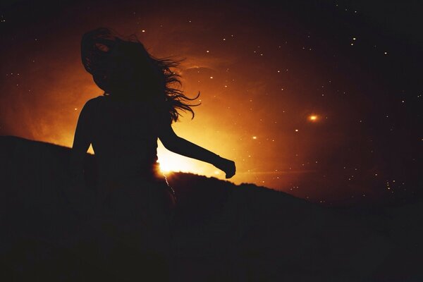 Gün batımında bir kızın karanlık silueti
