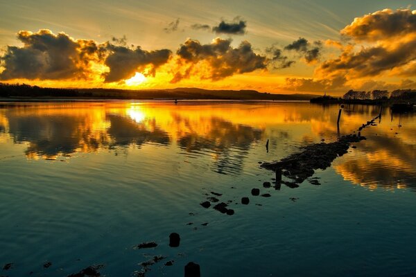 Okyanusun suyundaki gün batımının yansıması
