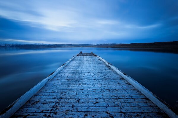 Alacakaranlıkta suyun üstünde gün batımı